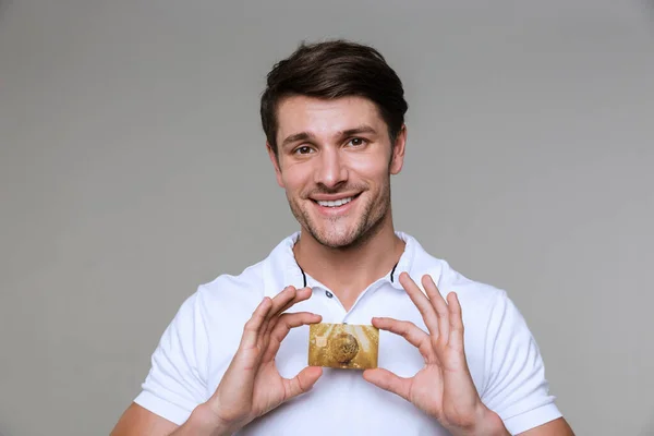 Man posing isolated holding debit card. — Stock Photo, Image