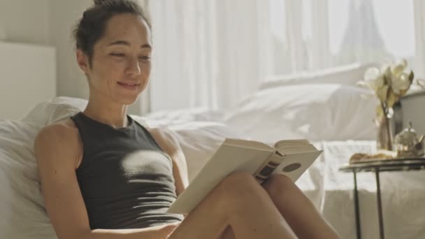 Soddisfatto Bella Donna Asiatica Lettura Libro Mentre Seduto Sul Pavimento — Video Stock