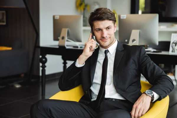 Retrato de un joven hombre de negocios con estilo sentado en el sillón con s —  Fotos de Stock