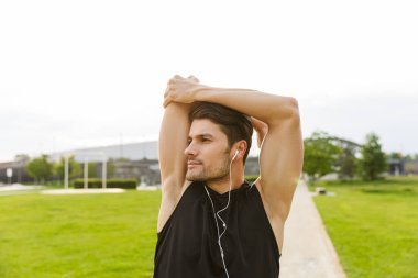 Kulaklıkla çalışan ve GR 'da koşan güçlü bir adamın görüntüsü