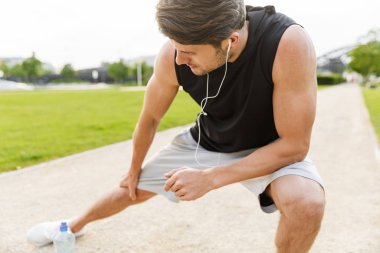 Kulaklıkla çalışan ve G 'de koşan odaklanmış bir adamın görüntüsü