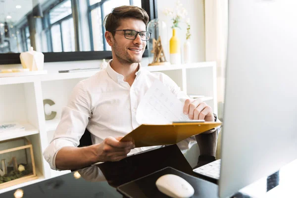 Imagen de feliz hombre de negocios sujetando portapapeles con papeles wh — Foto de Stock