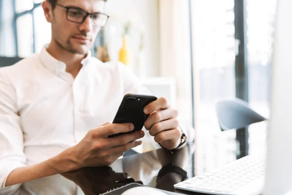 Obrázek sebevědomého obchodníka držícího mobilní telefon při práci — Stock fotografie