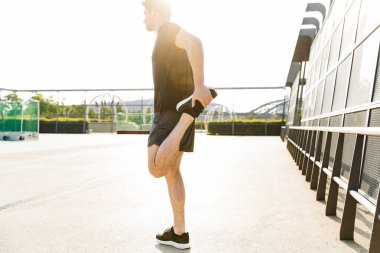 Spor grubunda kulaklık takan kaslı bir adamın görüntüsü