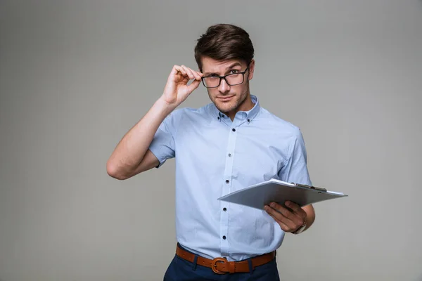 Serious business man holding clipboard. — Stock Photo, Image