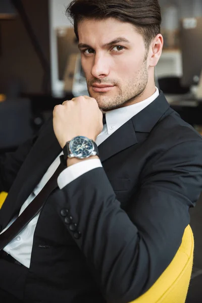 Porträtt av en maskulin ung affärsman i armbandsur sitti — Stockfoto