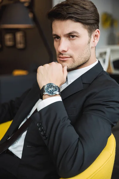 Retrato de joven hombre de negocios morena con reloj de pulsera sittin — Foto de Stock