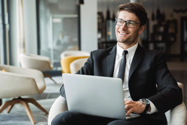 Retrato de joven empresario feliz sentado en sillón con regazo — Foto de Stock