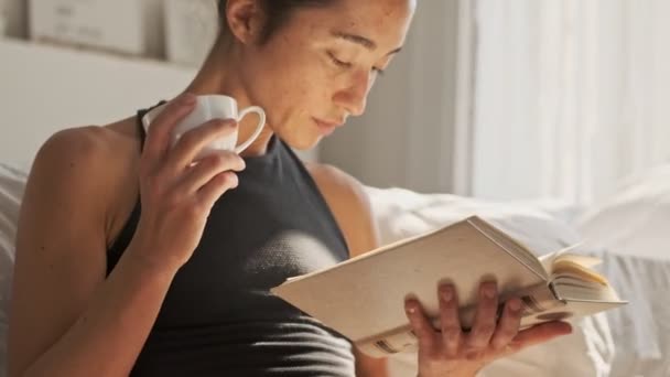 Close View Calm Pretty Asian Woman Reading Book Drinking Tea — Stock Video