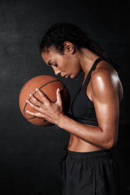 Spor giyim kuşamında basketbol oynayan güzel bir Afro-Amerikan kadını.