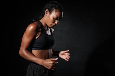 Spor kıyafetleriyle spor yapan odaklı Afrikalı Amerikalı bir kadının görüntüsü