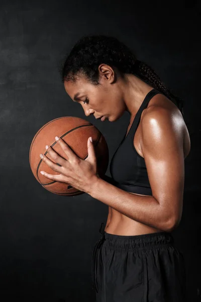 Obraz pięknej afrykańskiej kobiety w odzieży sportowej trzymającej koszykówkę — Zdjęcie stockowe