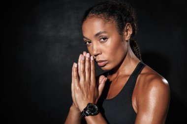 Image of african american woman in sportswear with palms together clipart