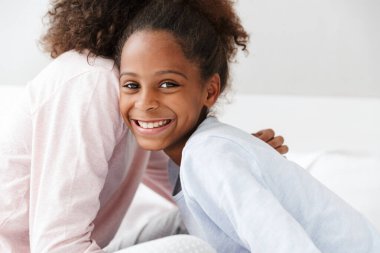 Afro-Amerikan kadın ve küçük kızının oturduğu resim. 