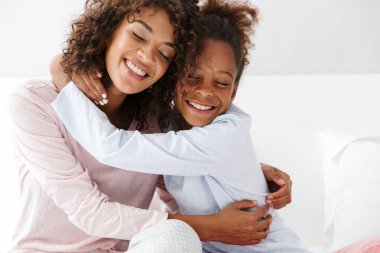 Afro-Amerikan kadın ve küçük kızının kucaklaşması. 