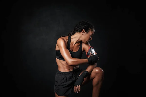 Imagen de una mujer afroamericana musculosa usando una funda de mano móvil — Foto de Stock