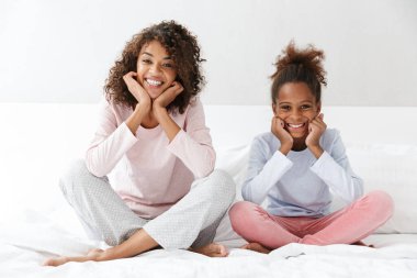 Afro-Amerikan kadın ve küçük kızının oturduğu resim. 