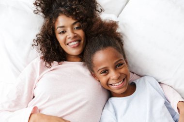 Neşeli Afro-Amerikan kadın ve kızı yalan söylüyor. 