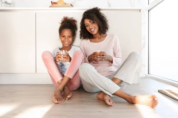 Smiling young mother and her little daughter wearing pajamas — Stock Photo, Image