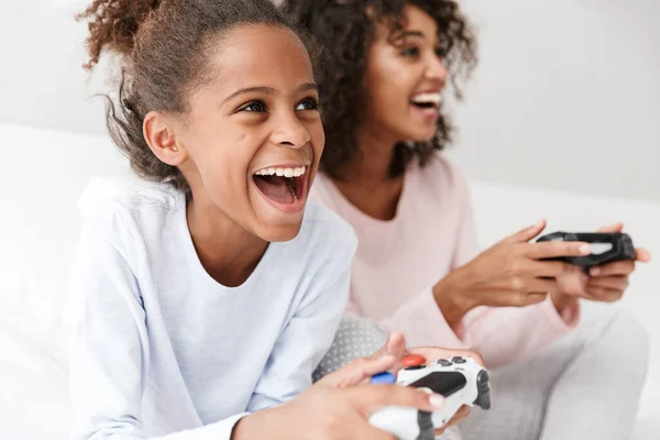 Imagen de mujer americana y niña jugando videojuegos con —  Fotos de Stock
