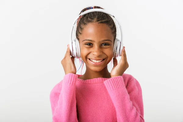 Imagen de niña afroamericana complacida escuchando música con auriculares — Foto de Stock