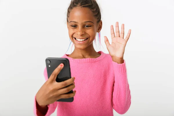 Imagem da menina americana africana bonita segurando celular e mão acenando Imagem De Stock