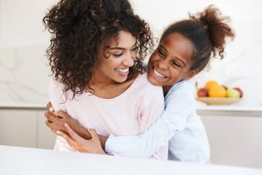 Afro-Amerikan kadın ve küçük kızının kucaklaşması. 