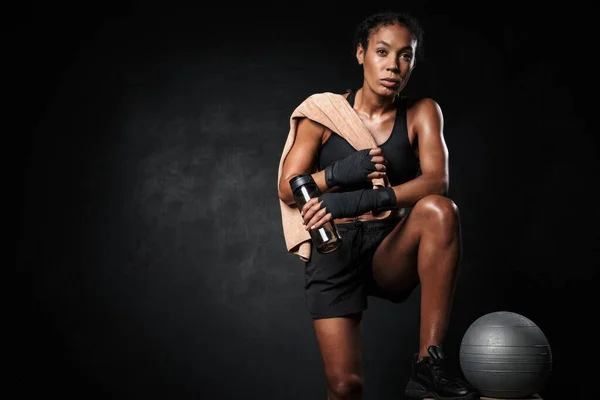 Bild einer afrikanisch-amerikanischen Frau mit Wasserflasche beim Fitnessball — Stockfoto