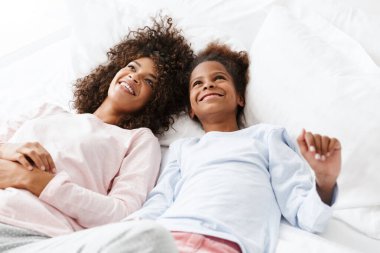 Neşeli Afro-Amerikan kadın ve kızı yalan söylüyor. 