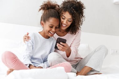 Amerikalı bir kadın ve küçük kızının cep telefonu kullanırken görüntüsü. 