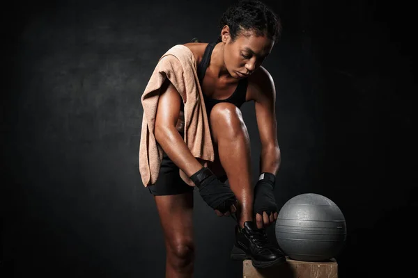 Εικόνα μιας Αφροαμερικανίδας που δένει τα κορδόνια της με μπάλα γυμναστικής — Φωτογραφία Αρχείου