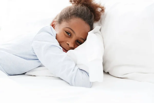 Esmer Afrikalı Amerikalı küçük bir kızın yatakta yatışı. — Stok fotoğraf