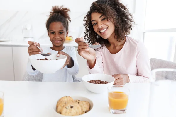 Obraz amerykańskiej kobiety i jej córki jedzących śniadanie w zestawie — Zdjęcie stockowe