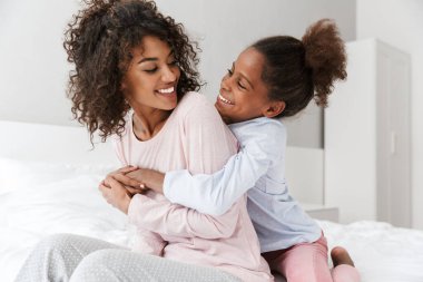 Afro-Amerikan kadın ve küçük kızının kucaklaşması. 