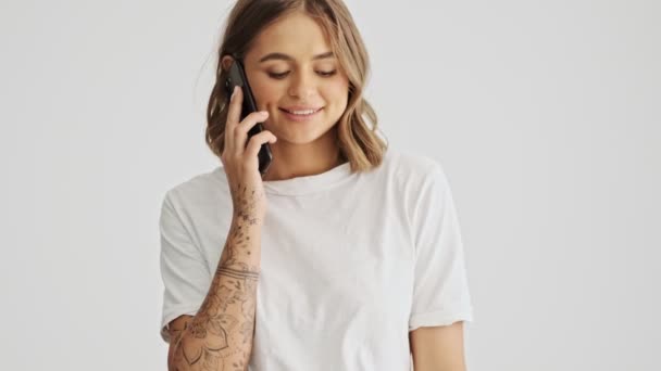 Glimlachende Jonge Vrouw Draagt Basic Shirt Met Een Oproep Haar — Stockvideo