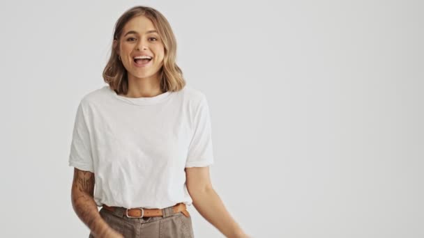 Rindo Jovem Mulher Vestindo Uma Camiseta Básica Branca Apontando Para — Vídeo de Stock