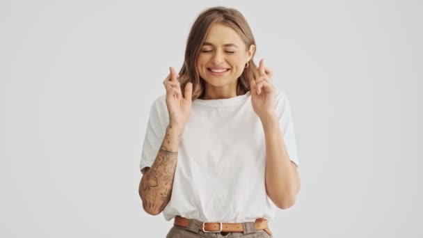 Mujer Joven Sonriente Con Una Camiseta Básica Cruzó Los Dedos — Vídeo de stock