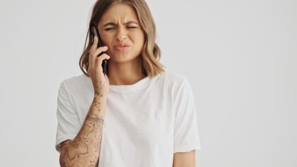 Tişört Giyen Genç Bir Kadının Beyaz Arka Planda Telefon Görüşmesi — Stok video