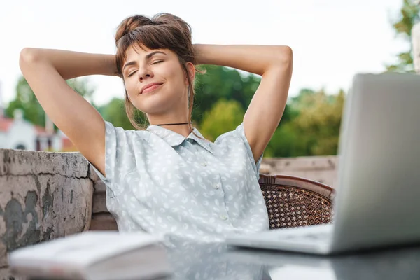 Pleased young beautiful woman using laptop computer on a balcony have a rest. — Stock Photo, Image