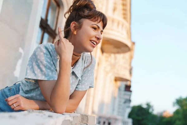 Šťastná mladá krásná žena stojící na balkóně a dívající se stranou. — Stock fotografie