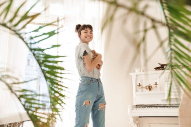 İyimser, neşeli, sevimli, güzel bir kadın evde kitap tutuyor..