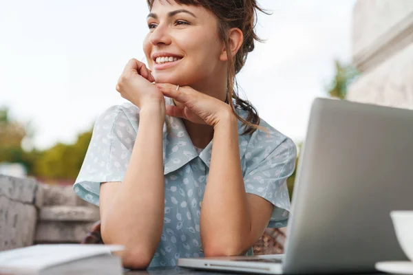 Joyeux joyeux jeune belle femme en utilisant un ordinateur portable sur un balcon . — Photo