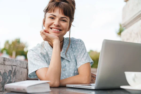 Happy cheery young beautiful woman using laptop computer on a balcony. — Stock Photo, Image