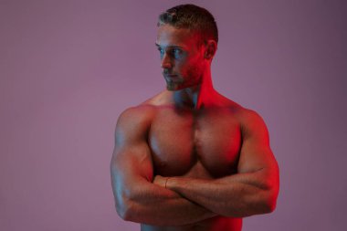 Yakışıklı genç sporcu, neon ışıklarda yalnız poz veriyor..