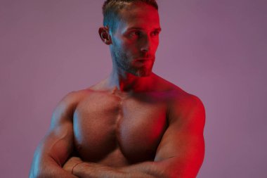 Yakışıklı genç sporcu, neon ışıklarda yalnız poz veriyor..