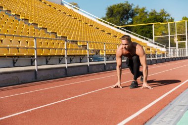 Aktif üstsüz sporcunun stad koşusuna hazırlanırken görüntüsü