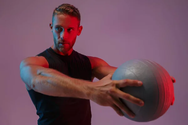 Guapo concentrado joven deportivo sosteniendo pelota . — Foto de Stock