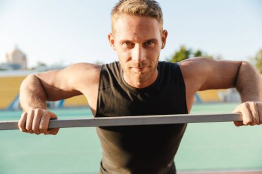 Yakışıklı sporcunun St. Louis 'deki metal korkuluklarda spor yaptığı görüntü.