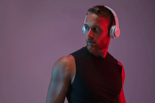 Jaki sport lubisz najbardziej? man posing isolated listening music with headphones. — Zdjęcie stockowe