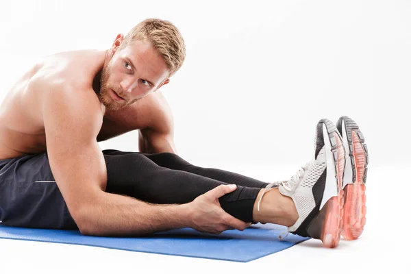 Självsäker attraktiv tröjlös idrottsman gör stretching — Stockfoto